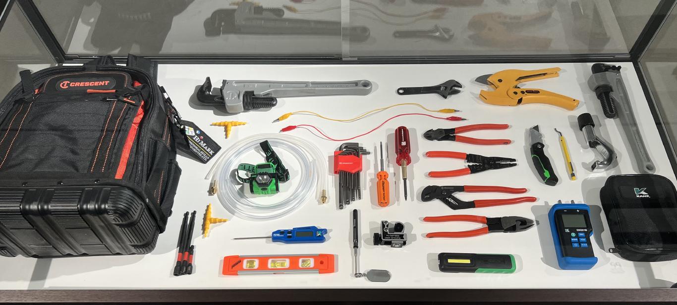 A collection of about 30 hand held tools arranged in a case.